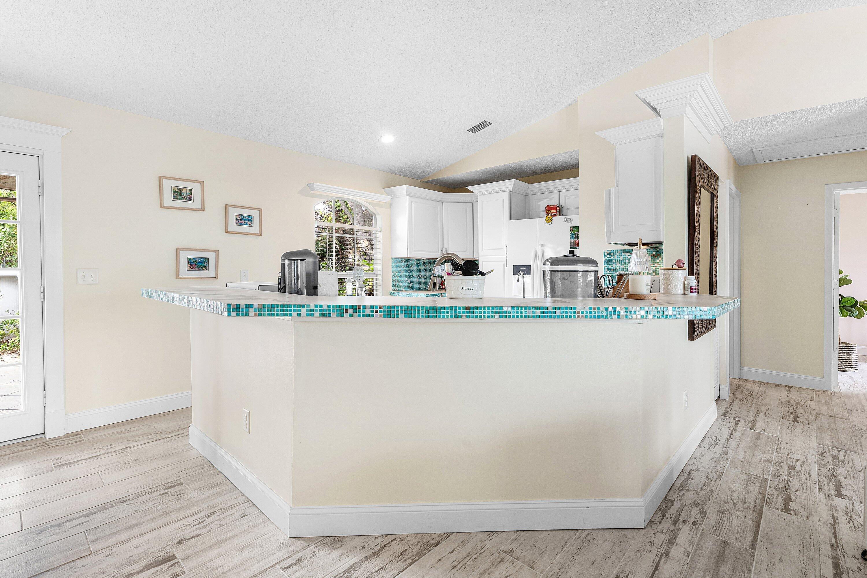 2114 Southeast Midtown Road Port St. Lucie, FL 34952 - Photo 10 of 41 a kitchen with stainless steel appliances granite countertop a refrigerator a sink a stove and white cabinets with wooden floor