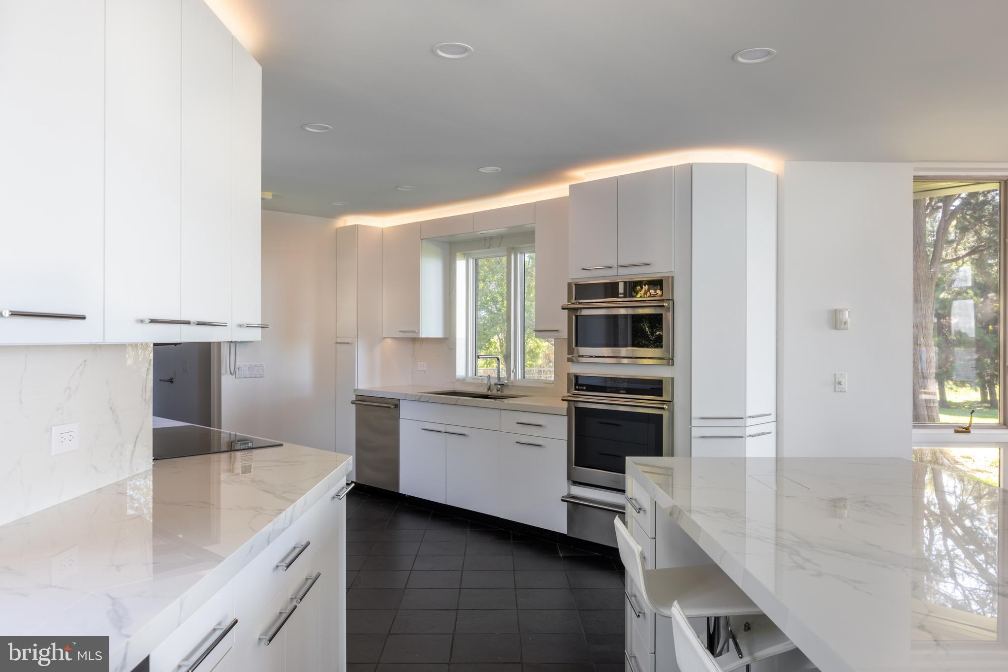 5084 Ferry Neck Road Royal Oak, MD 21662 - Photo 16 of 58 a large white kitchen with a sink and dishwasher a stove top oven with wooden floor
