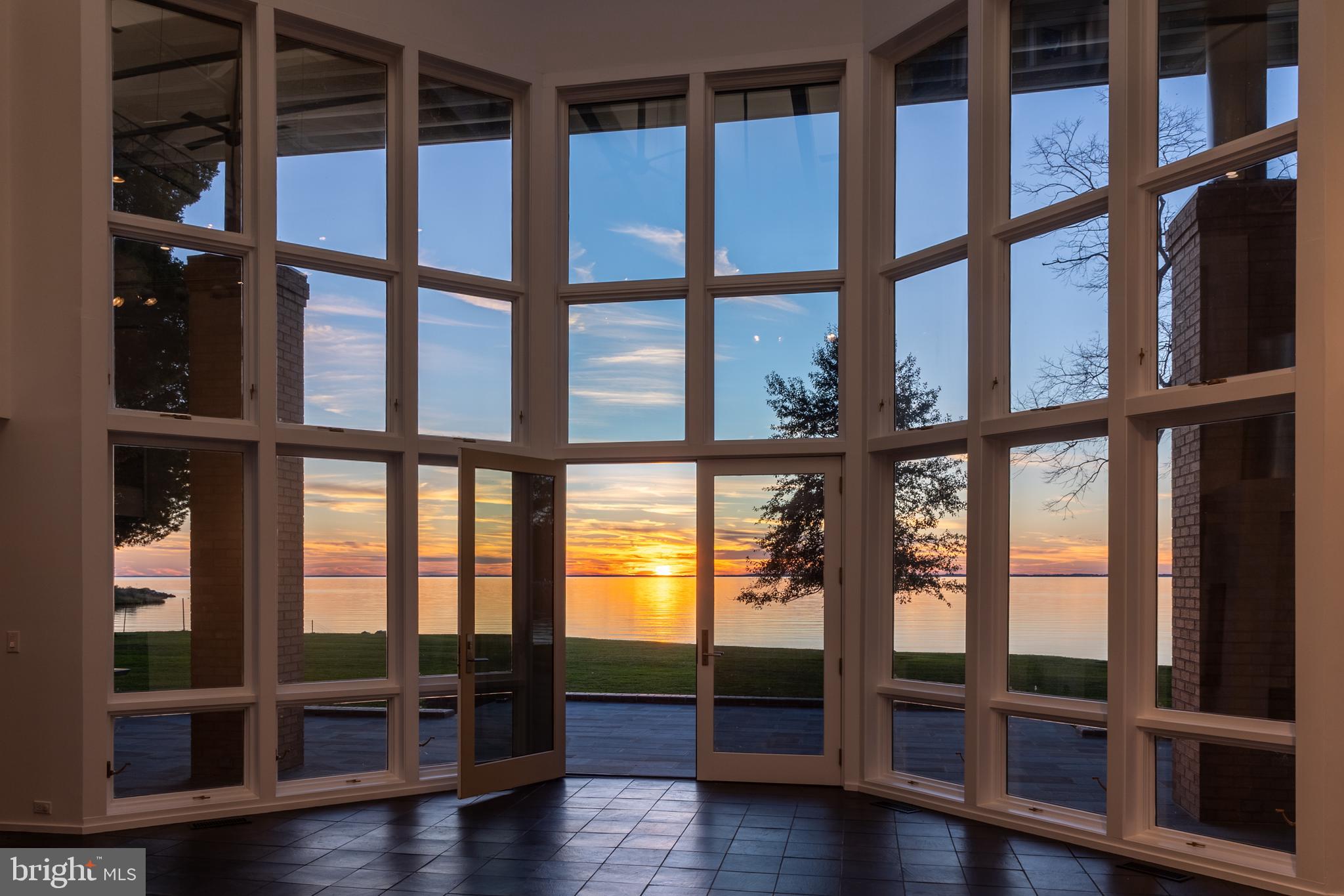 5084 Ferry Neck Road Royal Oak, MD 21662 - Photo 52 of 58 a view of an empty room with wooden floor and floor to ceiling window