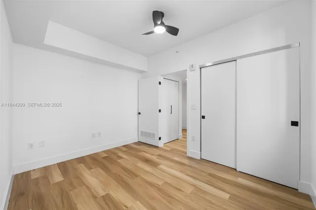 a view of room with hardwood floor and ceiling fan