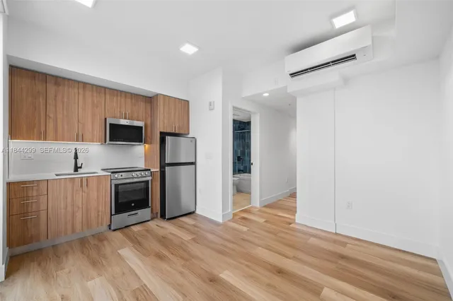 a kitchen with stainless steel appliances granite countertop a refrigerator and a stove top oven