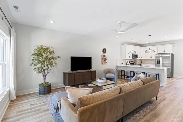 a living room with furniture a potted plant and a flat screen tv