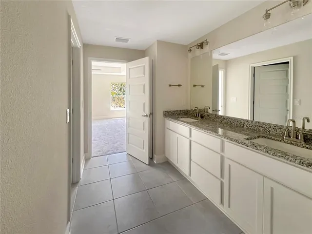 a spacious bathroom with a granite countertop sink a mirror and a