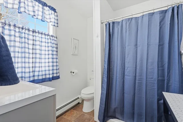 a bathroom with a sink a toilet and shower curtain