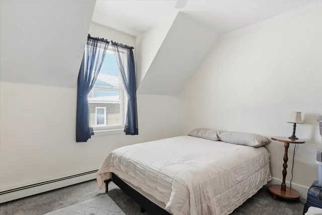 a bedroom with a bed next to a window
