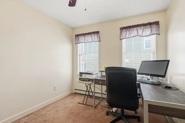 a view of a workspace with furniture and a window