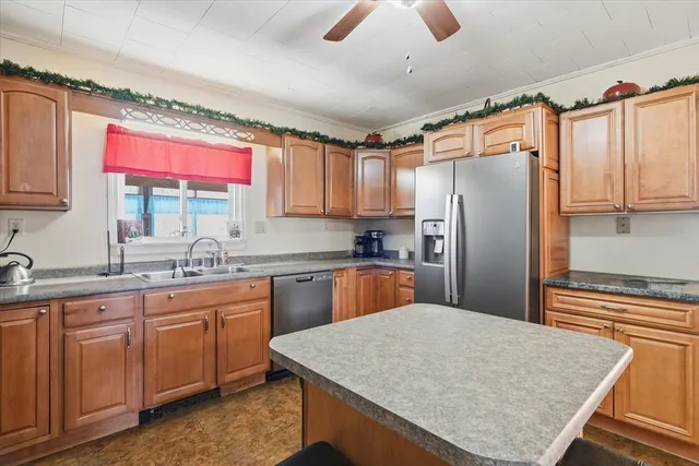 a kitchen with stainless steel appliances granite countertop a sink window and refrigerator