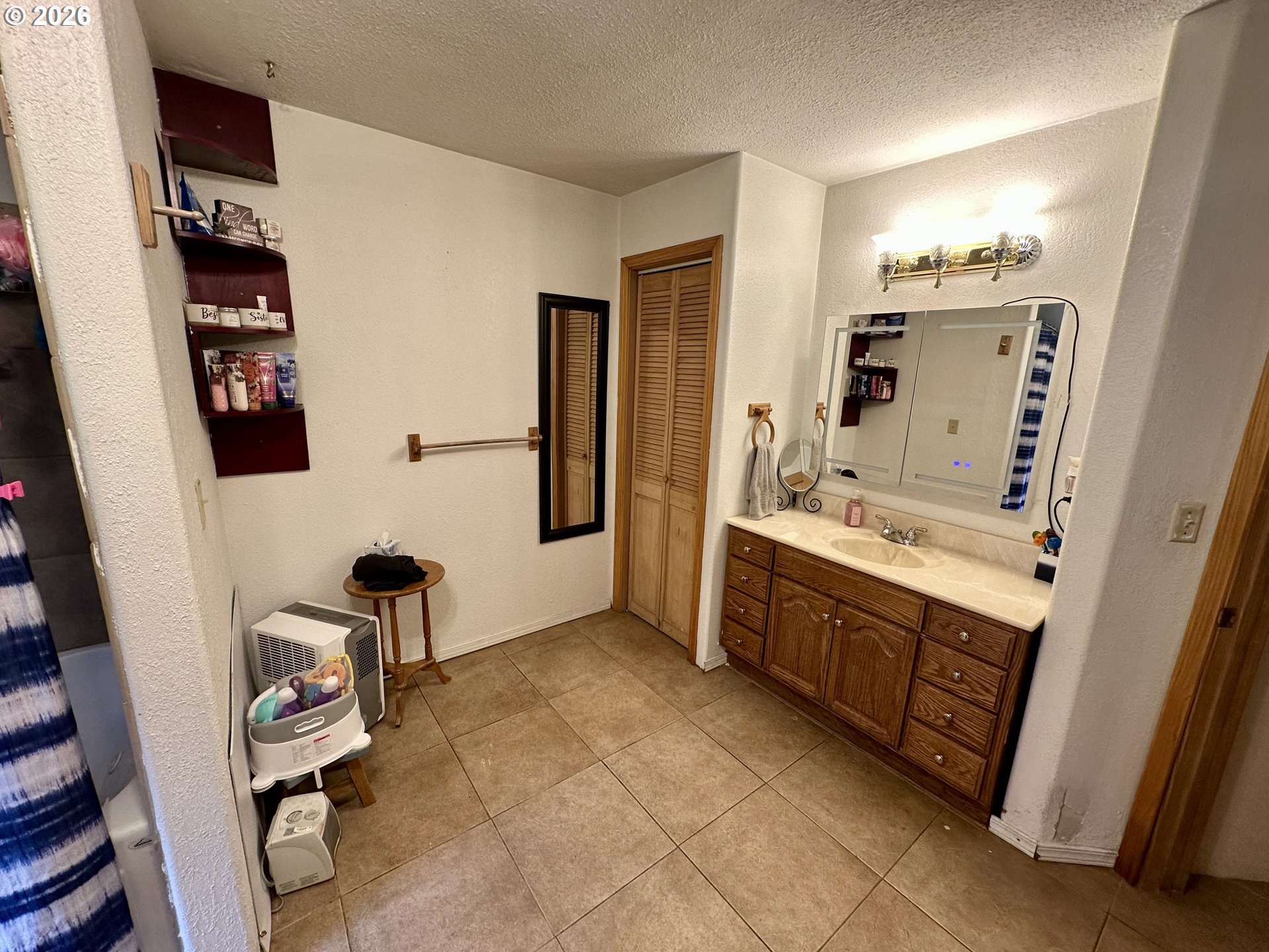 1910 Otter Slough Road Reedsport, OR 97467 - Photo 14 of 39 a bathroom with a double vanity sink a mirror and a bathtub