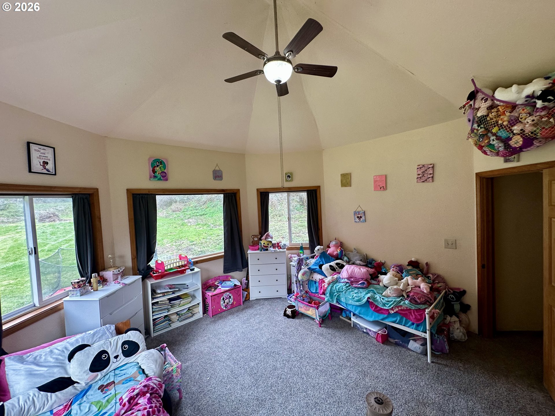 1910 Otter Slough Road Reedsport, OR 97467 - Photo 20 of 39 a bedroom with furniture toys ceiling fan and a window