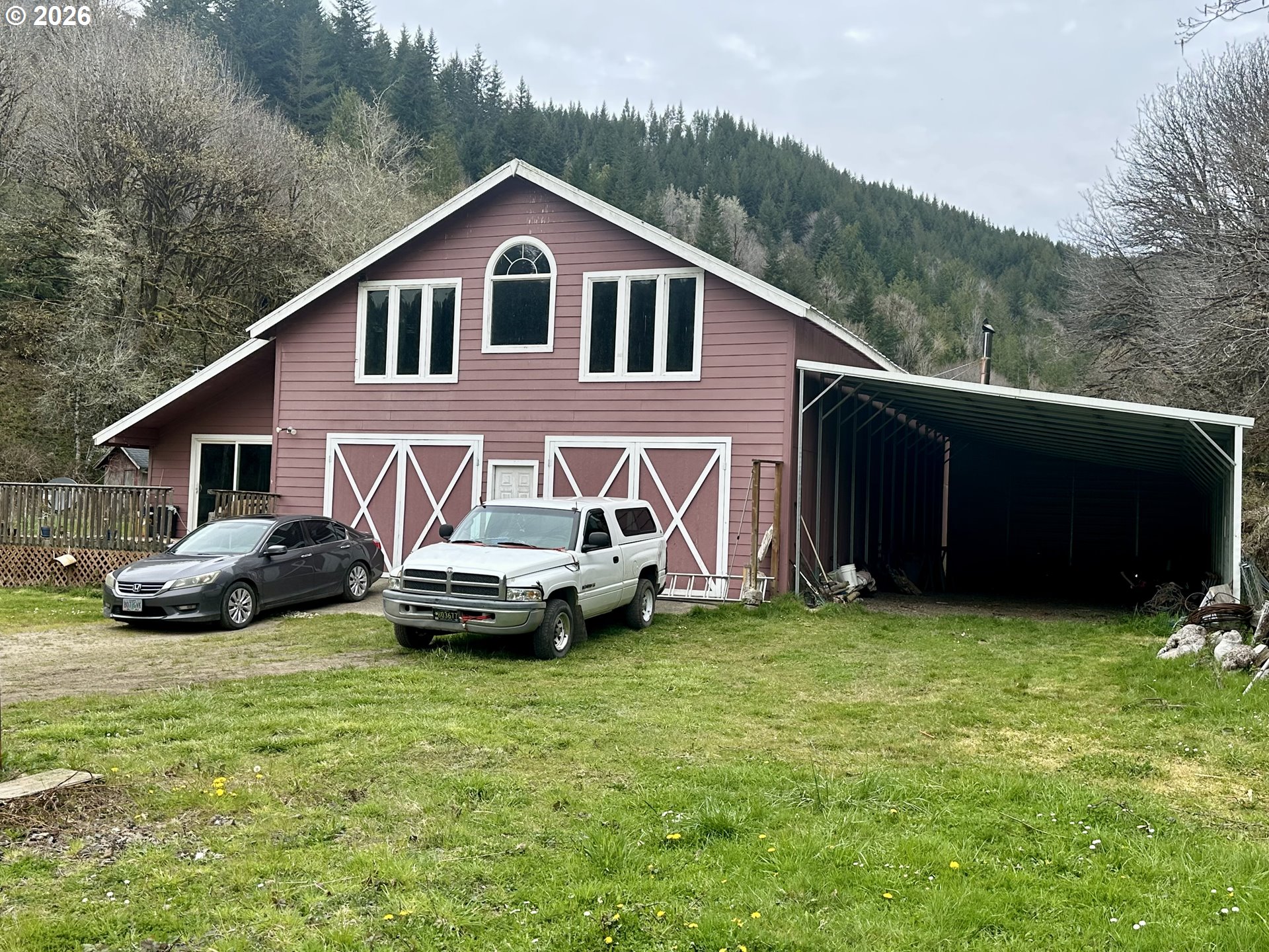 1910 Otter Slough Road Reedsport, OR 97467 - Photo 29 of 39 a view of a house with a yard and a car parked in it