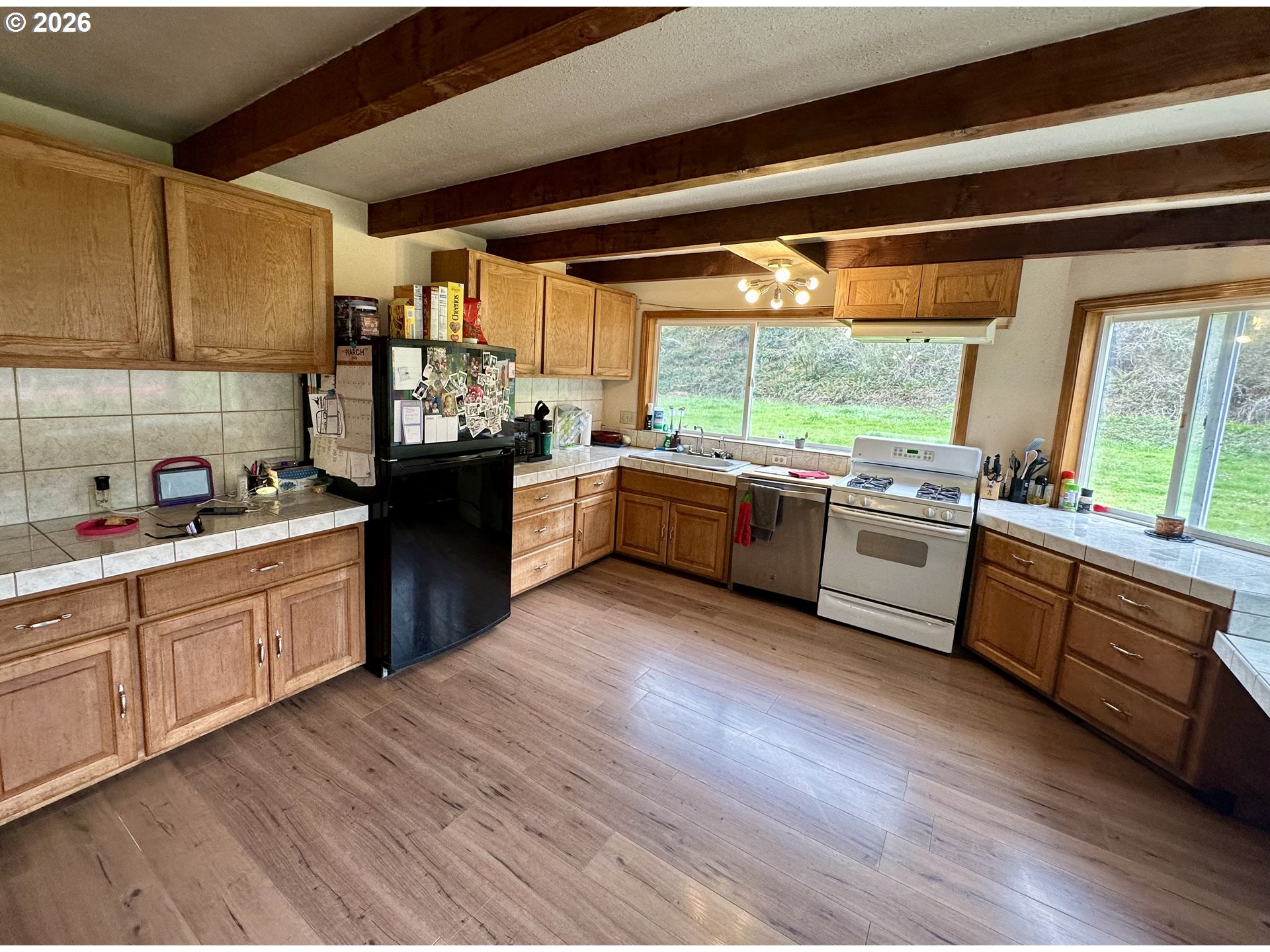 1910 Otter Slough Road Reedsport, OR 97467 - Photo 5 of 39 a large kitchen with stainless steel appliances granite countertop a lot of counter space and wooden floors