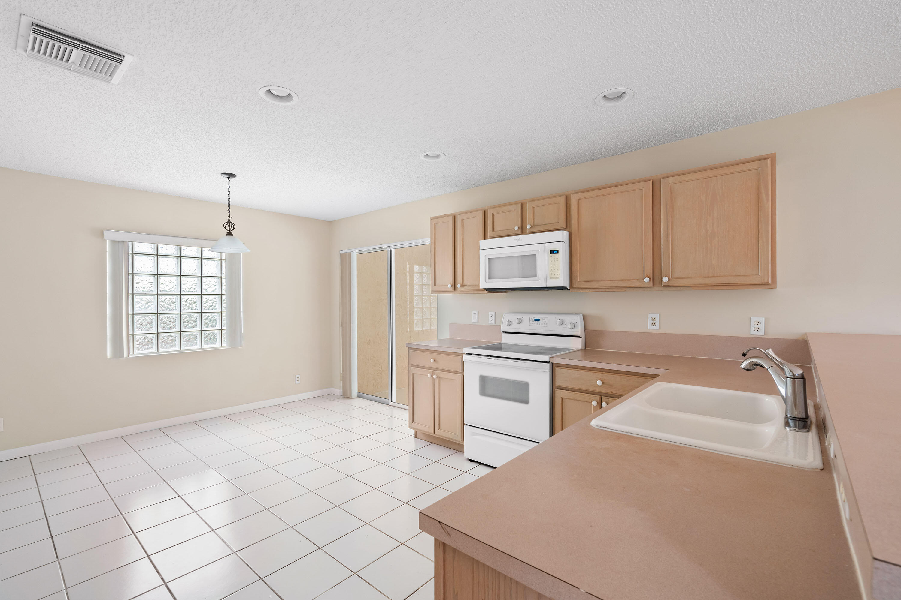 1104 Rialto Drive Boynton Beach, FL 33436 - Photo 8 of 50 a kitchen with stainless steel appliances a sink a stove a refrigerator cabinets and a window