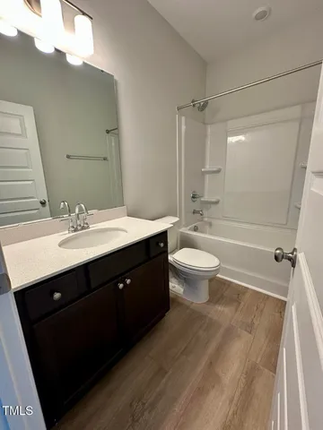 a bathroom with a sink vanity toilet and shower