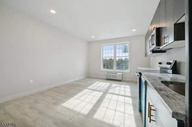 a kitchen with granite countertop a stove a sink and a microwave