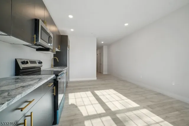 a kitchen with stainless steel appliances granite countertop a sink a stove and a microwave