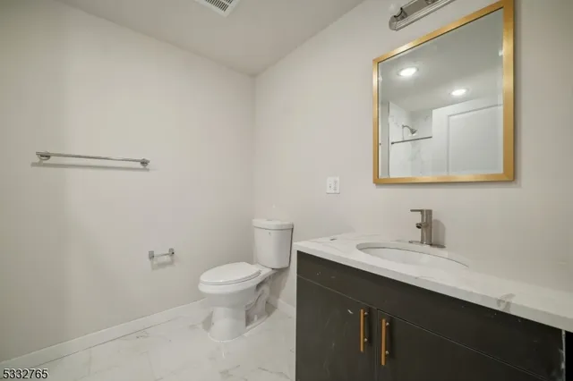 a bathroom with a sink a toilet a mirror and vanity