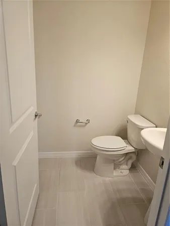 a white toilet sitting next to a white sink