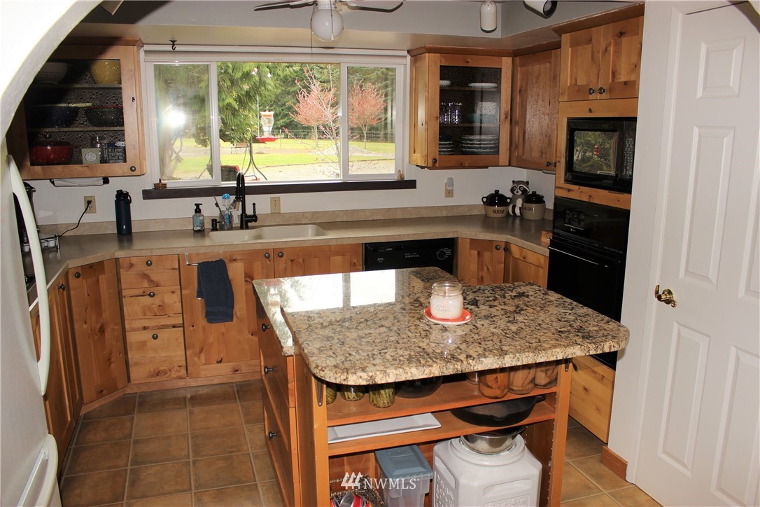 9344 Lundeen Road Southwest Rochester, WA 98579 - Photo 11 of 40 a kitchen with stainless steel appliances granite countertop a stove a sink and a refrigerator