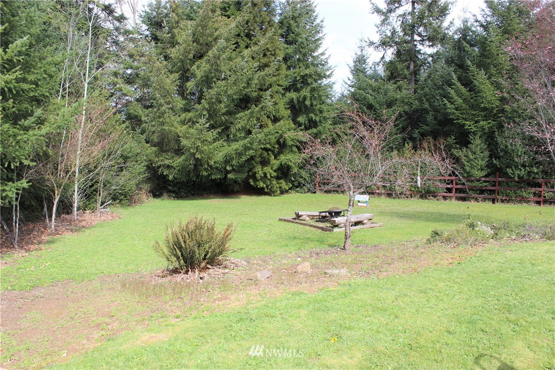 9344 Lundeen Road Southwest Rochester, WA 98579 - Photo 33 of 40 a garden with trees and wooden fence