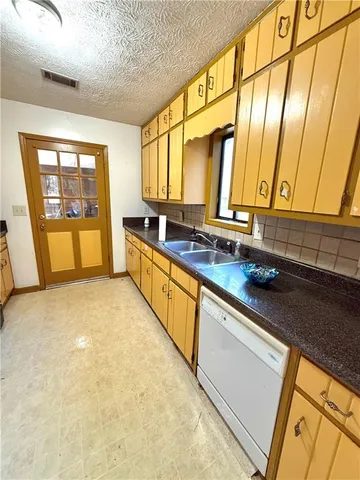 a large white kitchen with a large window