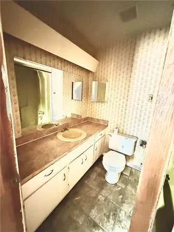 a view of house with backyard and trees in the background