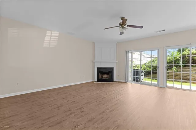 wooden floor fireplace and windows in an empty room