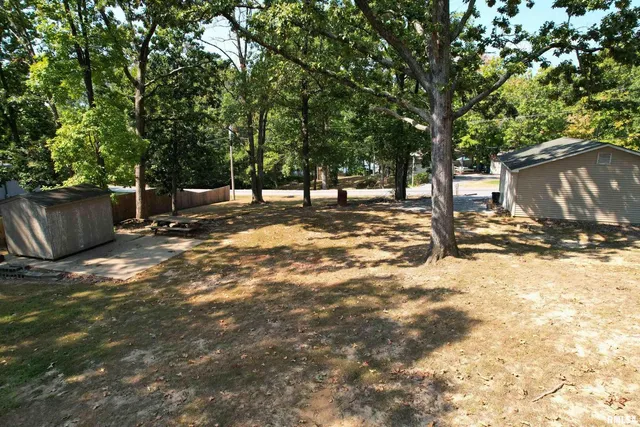 a view of a yard with wooden fence and a large tree