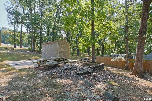 a backyard of a house with barbeque oven table and chairs