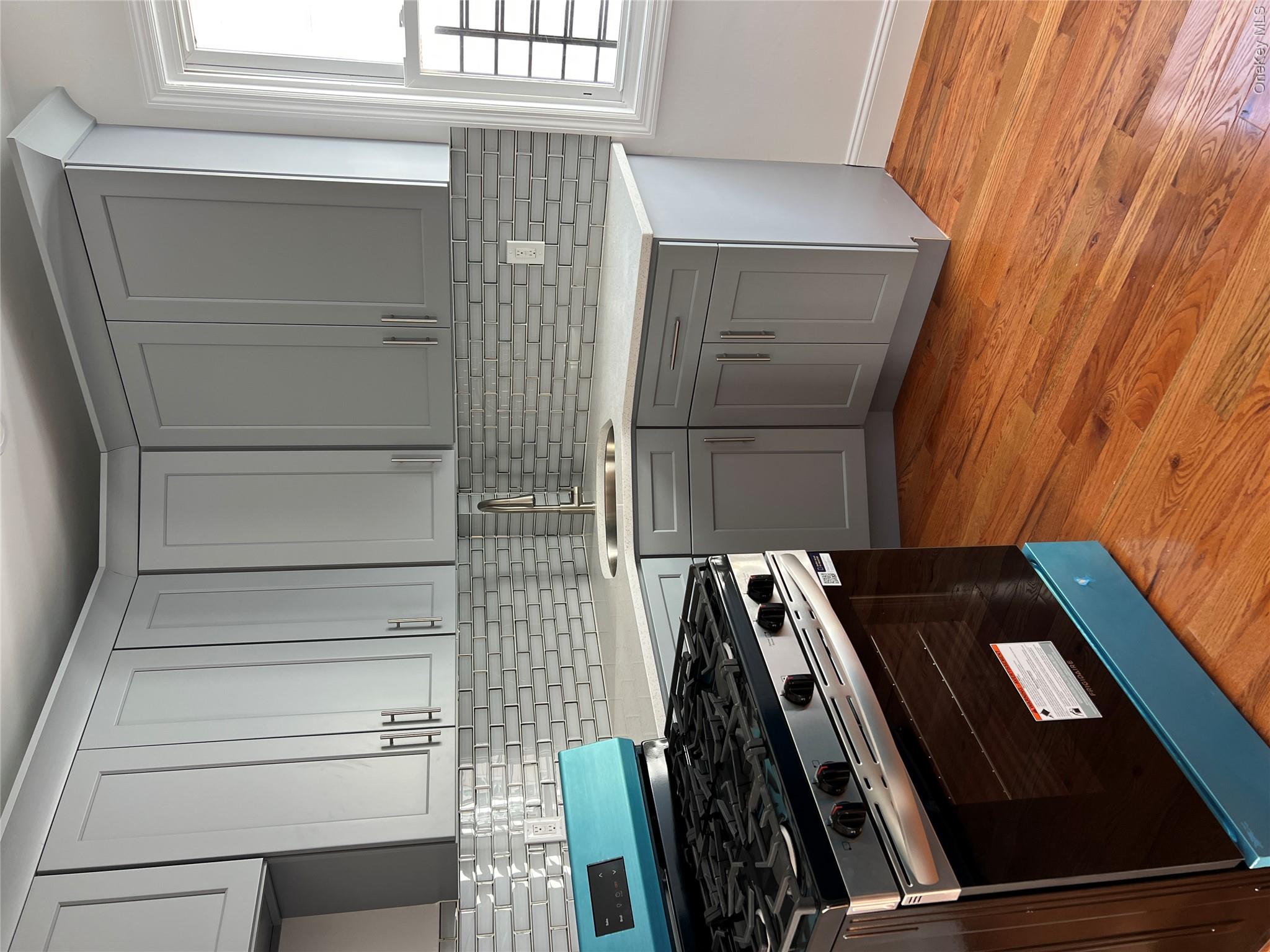216-25 136th Road, Unit 1 2 AND 3 Queens, NY 11413 - Photo 11 of 43 a kitchen with granite countertop wooden cabinets and a stove top oven