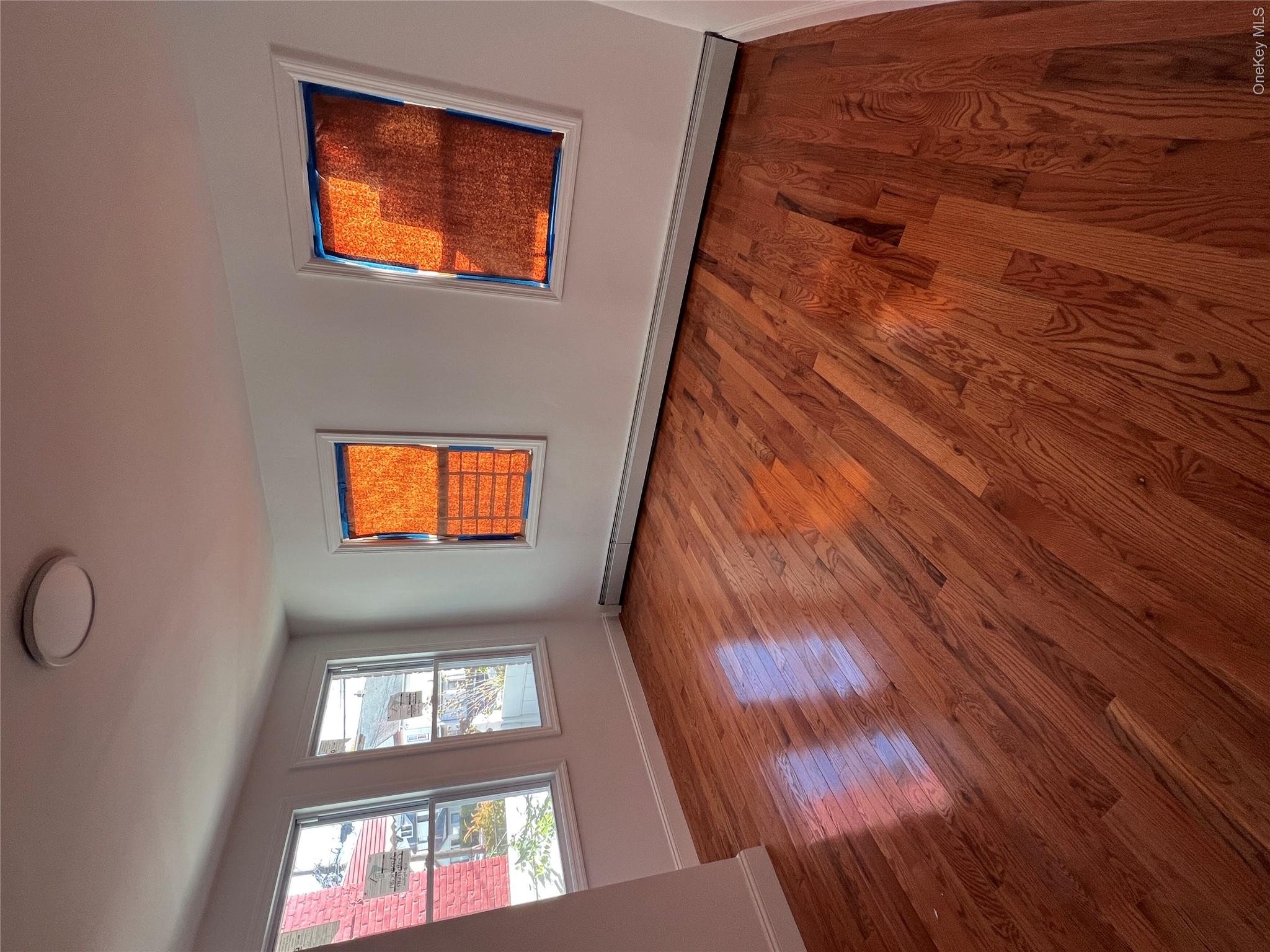 216-25 136th Road, Unit 1 2 AND 3 Queens, NY 11413 - Photo 4 of 43 a view of an empty room with wooden floor and a window