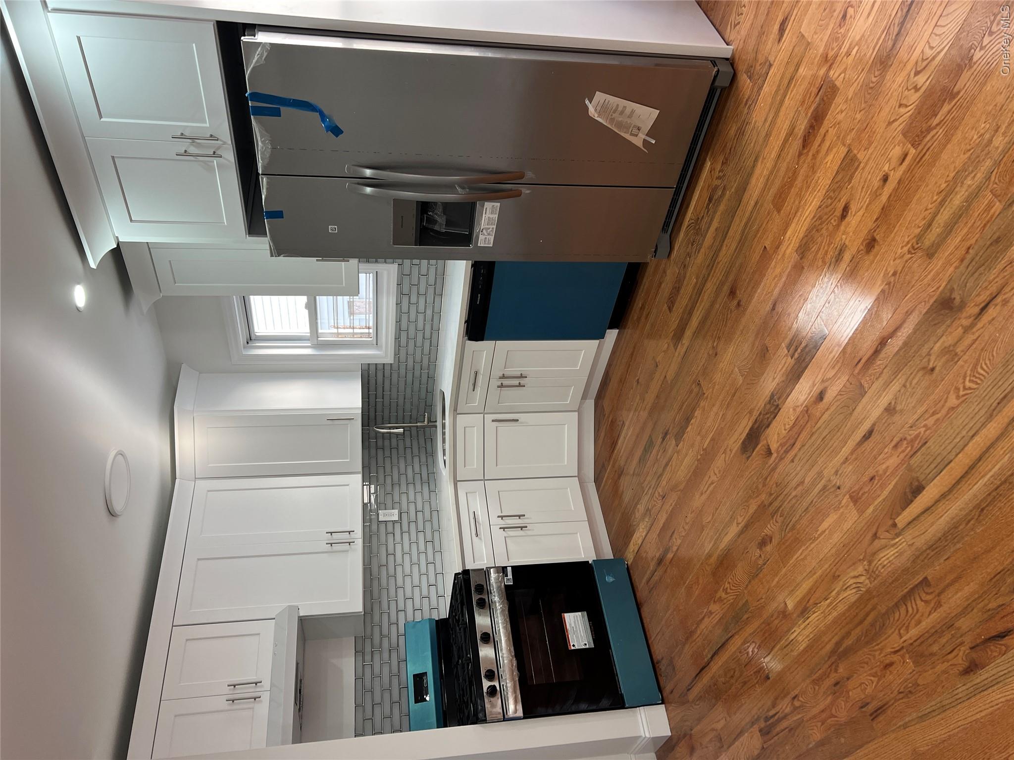 216-25 136th Road, Unit 1 2 AND 3 Queens, NY 11413 - Photo 43 of 43 a kitchen with granite countertop a refrigerator and a stove top oven