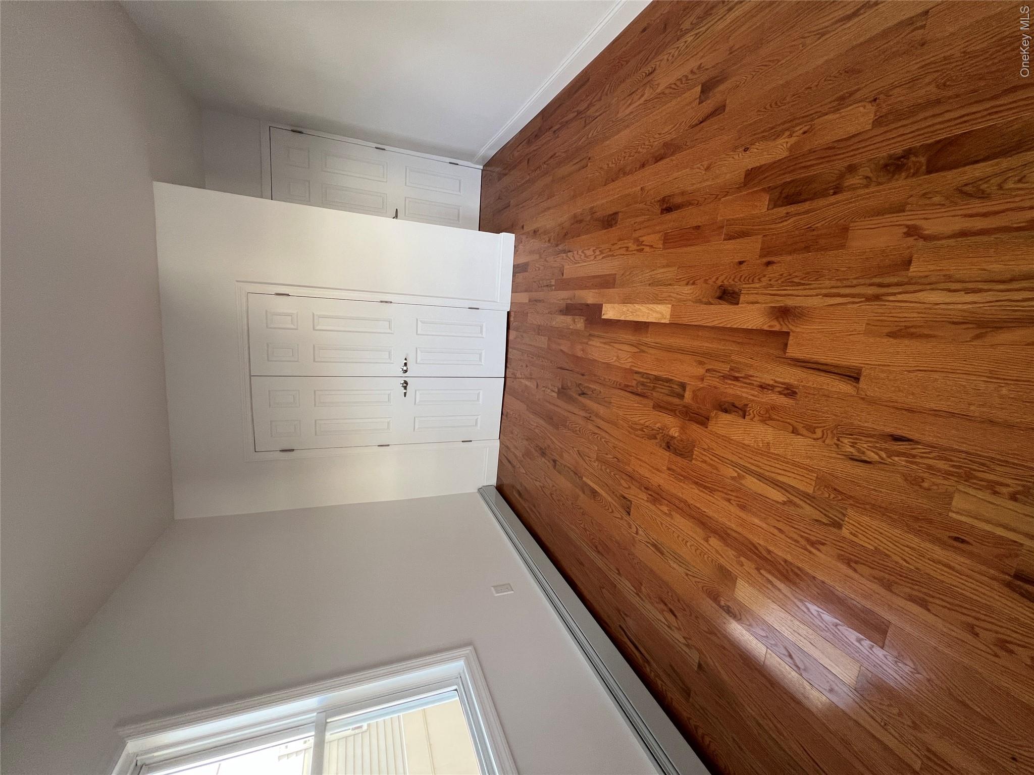 216-25 136th Road, Unit 1 2 AND 3 Queens, NY 11413 - Photo 10 of 43 an empty room with wooden floor and windows