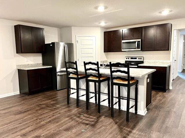 209 Laurel Hill Street Crestview, FL 32539 - Photo 5 of 24 a kitchen with stainless steel appliances wooden floor and chairs