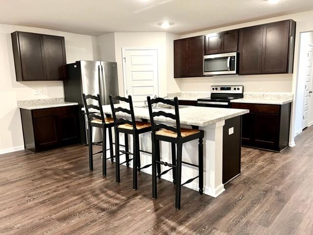 209 Laurel Hill Street Crestview, FL 32539 - Photo 7 of 24 a kitchen with stainless steel appliances wooden cabinets dining table and chairs