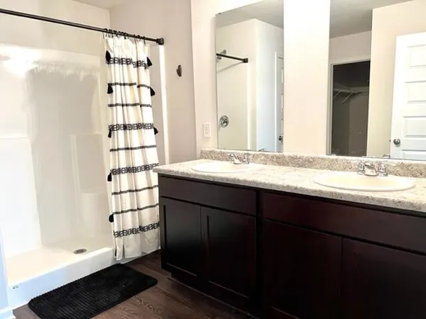 a bathroom with a granite countertop sink toilet a shower and a mirror