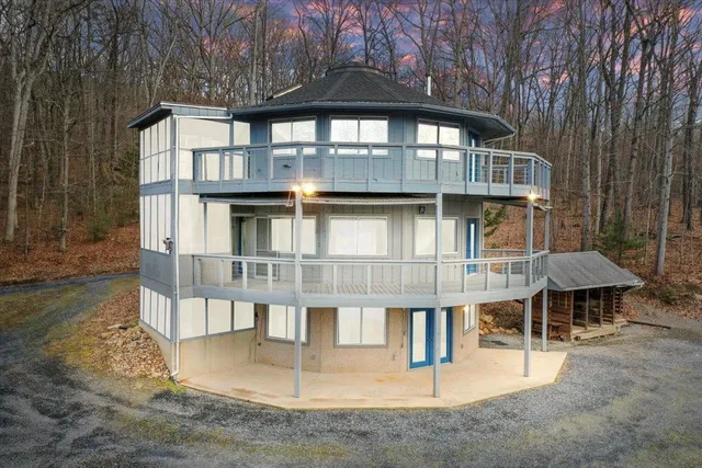 a view of wooden house with a large window and wooden fence