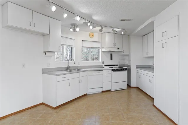 a kitchen with white cabinets stainless steel appliances and sink