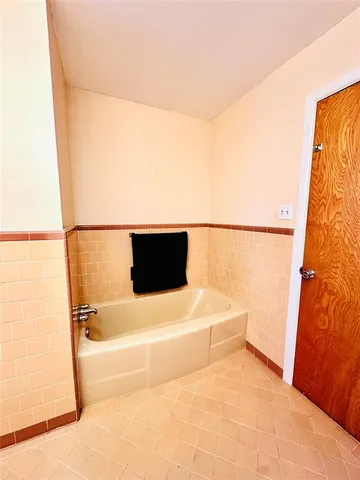 a bathroom with a tub sink and mirror