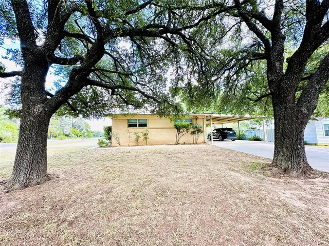 a view of a house with a backyard and a tree