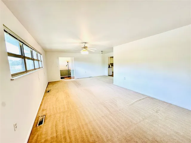 a view of a big room with wooden floor and windows