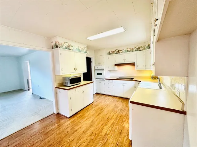 a kitchen with granite countertop a sink and a stove top oven