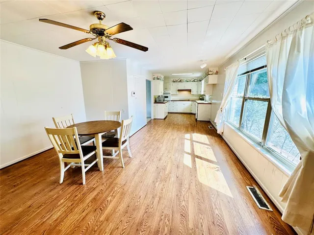 a view of a dining room with furniture a chandelier and wooden floor
