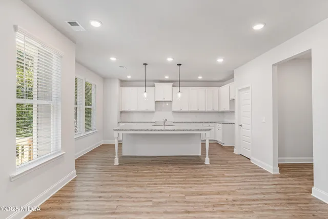 a view of kitchen with granite countertop window and wooden floor