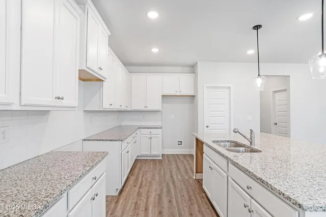 a kitchen with granite countertop a sink a counter space stainless steel appliances and cabinets