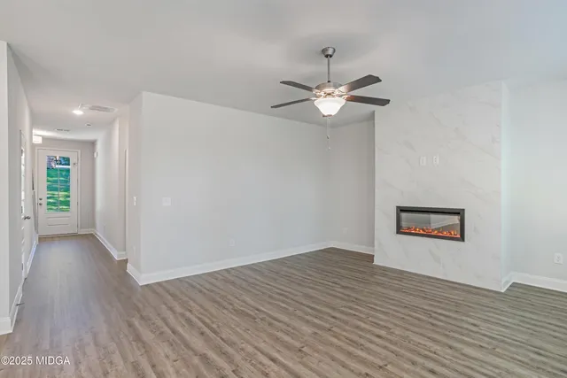 an empty room with wooden floor chandelier fan and closet area