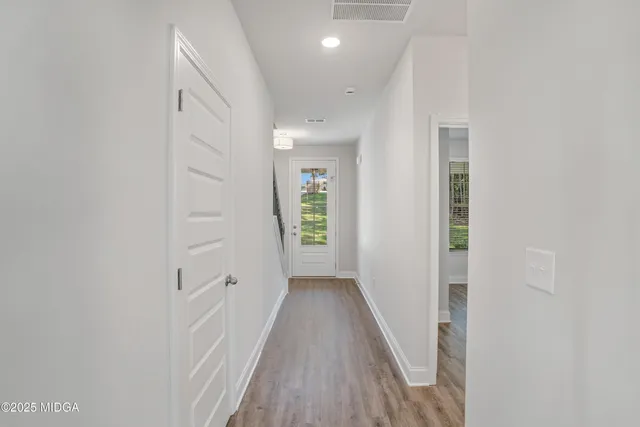 a view of a hallway with wooden floor