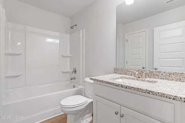 a bathroom with a granite countertop sink a toilet and a bathtub