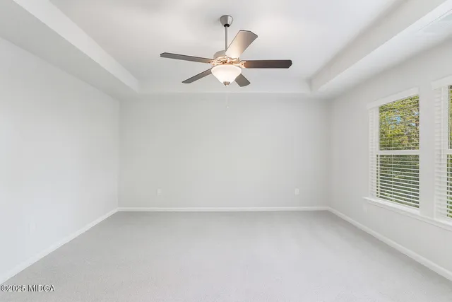 an empty room with a window and a fan