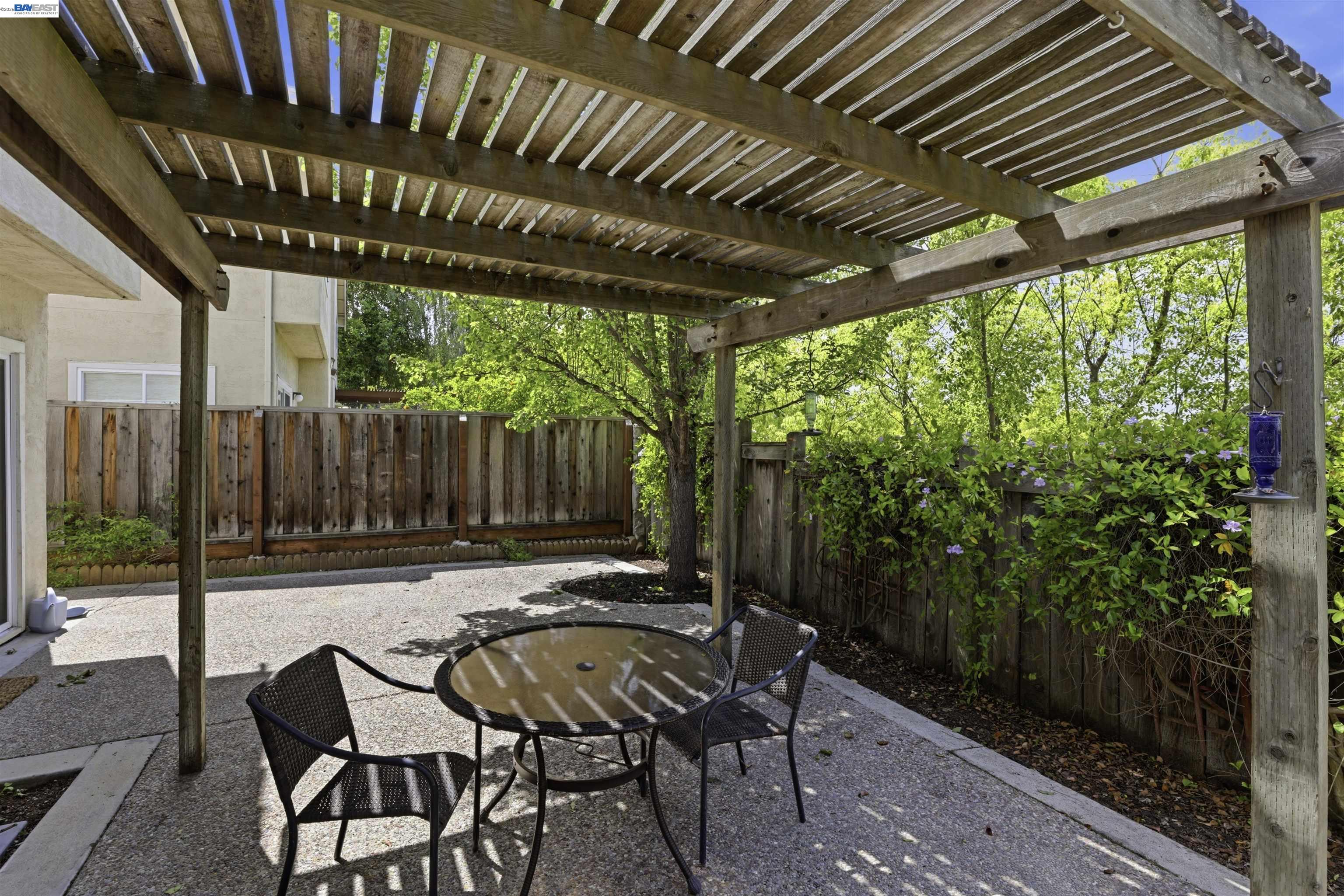 4161 Garibaldi Place Pleasanton, CA 94566 - Photo 38 of 47 a view of a patio with table and chairs with wooden floor and fence next to a yard