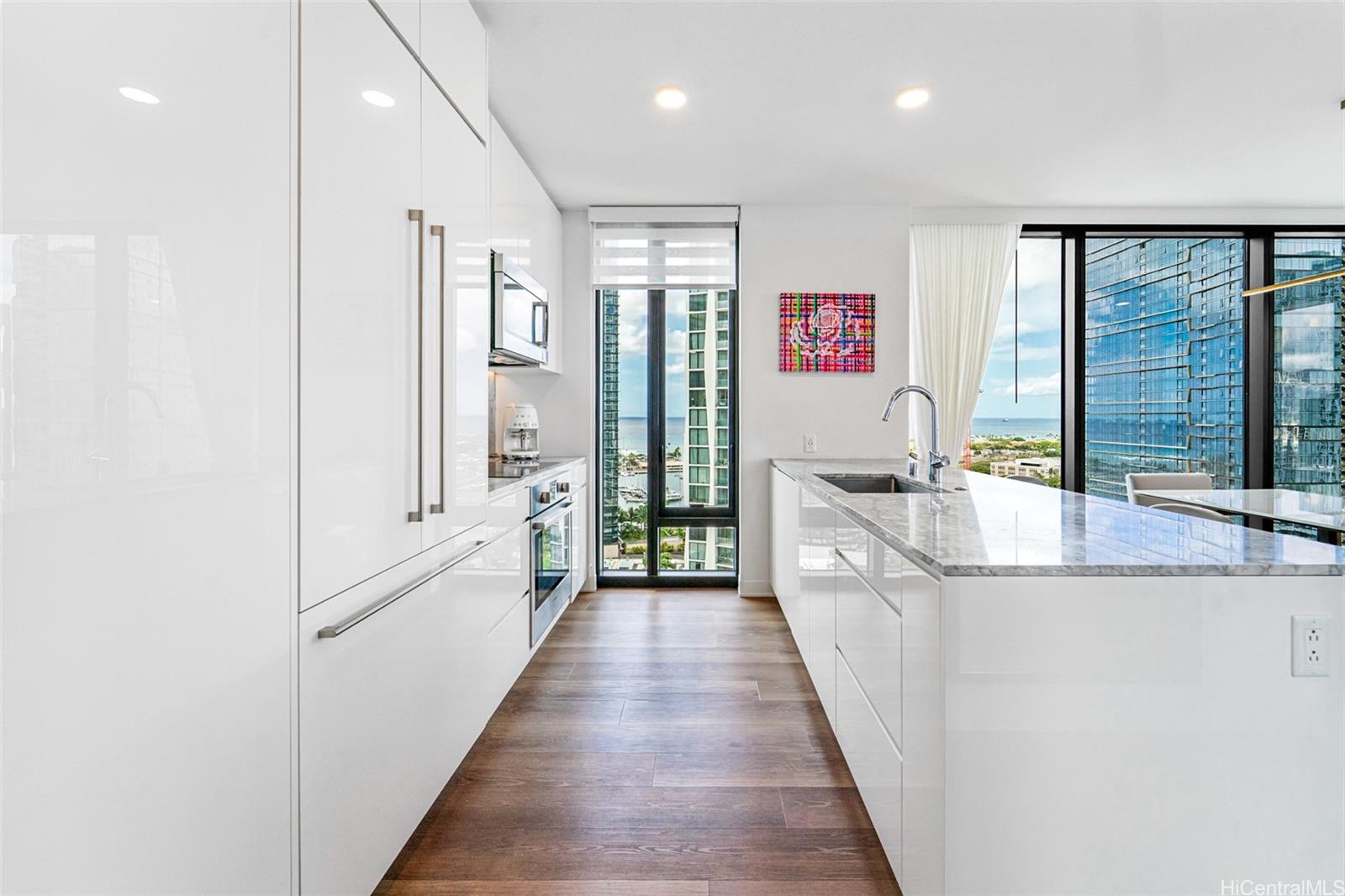 987 Queen Street, Unit 2001 Honolulu, HI 96814 - Photo 2 of 6 a large white kitchen with granite countertop a large counter top and sink